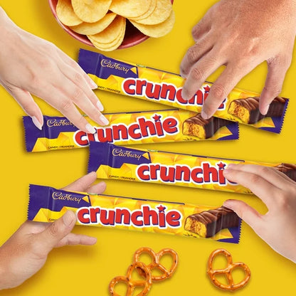 Cadbury Crunchie chocolate bars with hands reaching for them on a yellow background